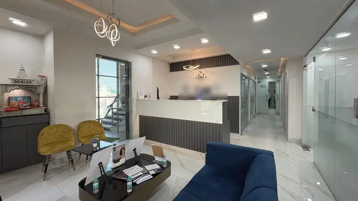 The reception and waiting area of a clinic in New Delhi, with a front desk, chairs and a long corridor.